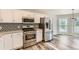 Kitchen features stainless steel appliances, decorative backsplash, and a window that provides natural light at 4495 Windmill Dr, Brighton, CO 80601