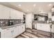 Well-lit kitchen featuring white cabinets, stainless steel appliances, and modern backsplash at 4495 Windmill Dr, Brighton, CO 80601