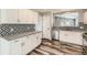 Bright kitchen with white cabinetry, gray countertops, and stylish backsplash for a modern touch at 4495 Windmill Dr, Brighton, CO 80601