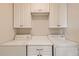 Functional laundry room with white cabinets and a folding table featuring a washer and dryer at 4495 Windmill Dr, Brighton, CO 80601