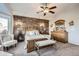 This bedroom offers a decorative wood accent wall plus bay window seating and a ceiling fan at 4495 Windmill Dr, Brighton, CO 80601