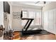 Exercise room with treadmill, wood floor, and natural light from windows at 910 Steele St, Denver, CO 80206