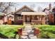 Charming brick home with a inviting covered front porch and well-manicured lawn at 910 Steele St, Denver, CO 80206