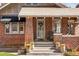 Charming brick home with a covered front porch and tasteful landscaping at 910 Steele St, Denver, CO 80206