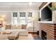 Cozy living room features a brick fireplace, white sofa, and bright windows at 910 Steele St, Denver, CO 80206