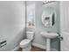 A half bathroom features a pedestal sink, toilet, and a window with natural light at 13694 Cherry St, Thornton, CO 80602