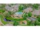 Aerial view of community buildings surrounding pool area, with mature landscaping, parking, and small body of water at 10087 E Hawaii Pl, Aurora, CO 80247