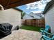 Cozy backyard featuring artificial turf, a BBQ grill, brick patio, and two Adirondack chairs at 10087 E Hawaii Pl, Aurora, CO 80247