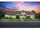 Inviting two-story home with a well-manicured lawn and a charming front porch, set against a beautiful sunset sky at 10087 E Hawaii Pl, Aurora, CO 80247