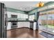 Bright kitchen with white cabinets, stainless steel appliances, and a view to the outdoor patio at 10087 E Hawaii Pl, Aurora, CO 80247