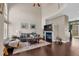 Cozy living room with high ceilings, fireplace, hardwood floors, and natural light from a large window at 10087 E Hawaii Pl, Aurora, CO 80247
