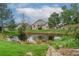 Backyard with a community pond surrounded by mature trees and lush landscaping at 10087 E Hawaii Pl, Aurora, CO 80247