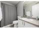 Well-lit bathroom featuring a shower and toilet adjacent to a vanity with a mirror and cabinet at 9758 Laredo St # 37C, Commerce City, CO 80022