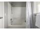 Clean, white bathtub with a showerhead and neutral walls, enclosed by a shower curtain at 9758 Laredo St # 37C, Commerce City, CO 80022