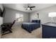 Cozy bedroom with ceiling fan, desk, and a bed with navy accents at 9758 Laredo St # 37C, Commerce City, CO 80022