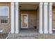 Charming front porch with stone accents, white columns, and a glass door at 9758 Laredo St # 37C, Commerce City, CO 80022