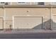 Attached garage with a beige door and stone accents, providing convenient parking and storage at 9758 Laredo St # 37C, Commerce City, CO 80022