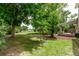 Lush backyard featuring mature trees and a spacious grassy area at 2212 S Naples Way, Aurora, CO 80013