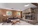 Finished basement with a stone fireplace and wood paneled wall creates a cozy living space at 2212 S Naples Way, Aurora, CO 80013