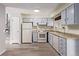 Kitchen featuring white appliances, light blue cabinetry, and ample countertop space at 2212 S Naples Way, Aurora, CO 80013