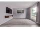 Spacious living room featuring plush carpeting, a large window, and a modern entertainment center at 2212 S Naples Way, Aurora, CO 80013