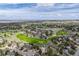 Aerial of a residential area and golf course with rolling green fairways surrounded by homes and natural landscape at 8446 Lightening View Dr, Parker, CO 80134