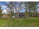 Extensive backyard featuring lush green grass and mature trees, creating a private outdoor setting at 8446 Lightening View Dr, Parker, CO 80134