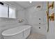 Bright bathroom with a soaking tub, rain shower head, marble walls, and mosaic tile floor at 8446 Lightening View Dr, Parker, CO 80134