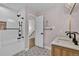 Bathroom featuring tiled shower with modern fixtures, double vanity, and stylish patterned floor at 8446 Lightening View Dr, Parker, CO 80134