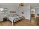 Bright bedroom featuring hardwood floors, a statement ceiling fixture, and a view of the bathroom at 8446 Lightening View Dr, Parker, CO 80134