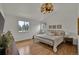 Sun-filled bedroom with hardwood floors, a wrought iron bed, and two windows with tree views at 8446 Lightening View Dr, Parker, CO 80134