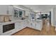 Bright kitchen with white cabinets, hardwood floors, and a view of the cozy living space at 8446 Lightening View Dr, Parker, CO 80134