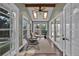 This sunroom has white trim windows and doors, a vaulted ceiling with skylights, and wood flooring at 8446 Lightening View Dr, Parker, CO 80134
