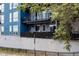 Blue apartment building features multiple balconies with black metal railings, blending modern style and outdoor living at 2460 W 29Th Ave # 104, Denver, CO 80211
