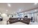 Wide-open basement features a large sectional couch, workout equipment, and bar with backyard access at 18280 W 85Th Dr, Arvada, CO 80007