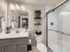 Stylish bathroom featuring a tiled shower, modern fixtures, and a vanity with decor at 18280 W 85Th Dr, Arvada, CO 80007