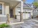 Inviting front porch with stone pillars, a wreath on the front door, and a two-car garage at 18280 W 85Th Dr, Arvada, CO 80007