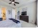 Comfortable main bedroom boasts a ceiling fan, artwork, and a modern dresser with mounted television at 18280 W 85Th Dr, Arvada, CO 80007
