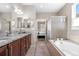 Spacious bathroom with dual vanities, granite countertops, a soaking tub, and a separate shower at 2065 Sage Grouse Way, Castle Rock, CO 80109
