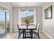 Bright dining room features wood table, upholstered chairs, light fixture, and views of the outdoor landscape at 2065 Sage Grouse Way, Castle Rock, CO 80109