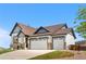 This exterior shot shows a charming home with a three-car garage, great curb appeal and a well manicured lawn at 2065 Sage Grouse Way, Castle Rock, CO 80109
