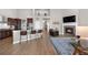 Open-concept living area features a kitchen island with seating, a fireplace, and hardwood floors at 2065 Sage Grouse Way, Castle Rock, CO 80109