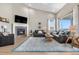 Bright living room with a cozy fireplace, vaulted ceilings, and ample natural light from large windows at 2065 Sage Grouse Way, Castle Rock, CO 80109