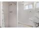 Clean bathroom featuring a shower, toilet, and pedestal sink offering essential amenities at 2291 W 54Th Ave, Denver, CO 80221