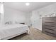 Bright bedroom features a bed and dresser, with a door to a possible ensuite bathroom at 2291 W 54Th Ave, Denver, CO 80221