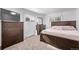 Bright bedroom features a wooden bed frame, dresser, TV and two bright windows for natural light at 2291 W 54Th Ave, Denver, CO 80221