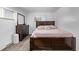 Cozy bedroom features a wooden bed frame, dresser and a bright window for natural light at 2291 W 54Th Ave, Denver, CO 80221