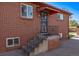 Home entryway featuring a secure entry door, brick steps, and metal awning at 2291 W 54Th Ave, Denver, CO 80221