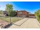 A brick home with a fenced yard and a long driveway to a detached garage at 2291 W 54Th Ave, Denver, CO 80221