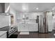 Well-lit kitchen with white cabinets, stainless steel appliances, and modern countertops at 2291 W 54Th Ave, Denver, CO 80221